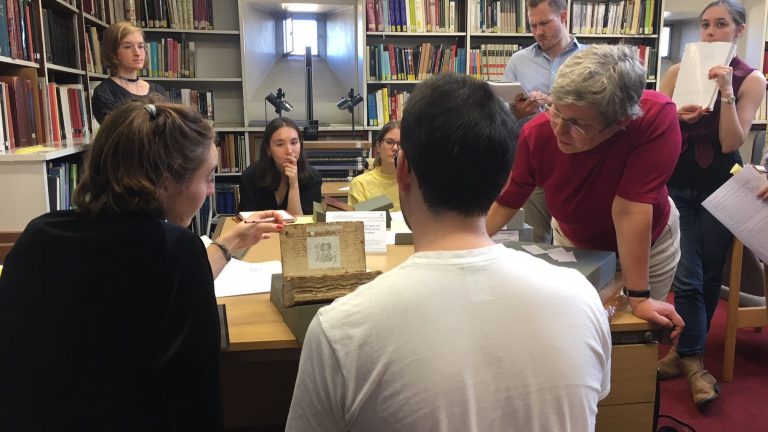 Student group studying a manuscript